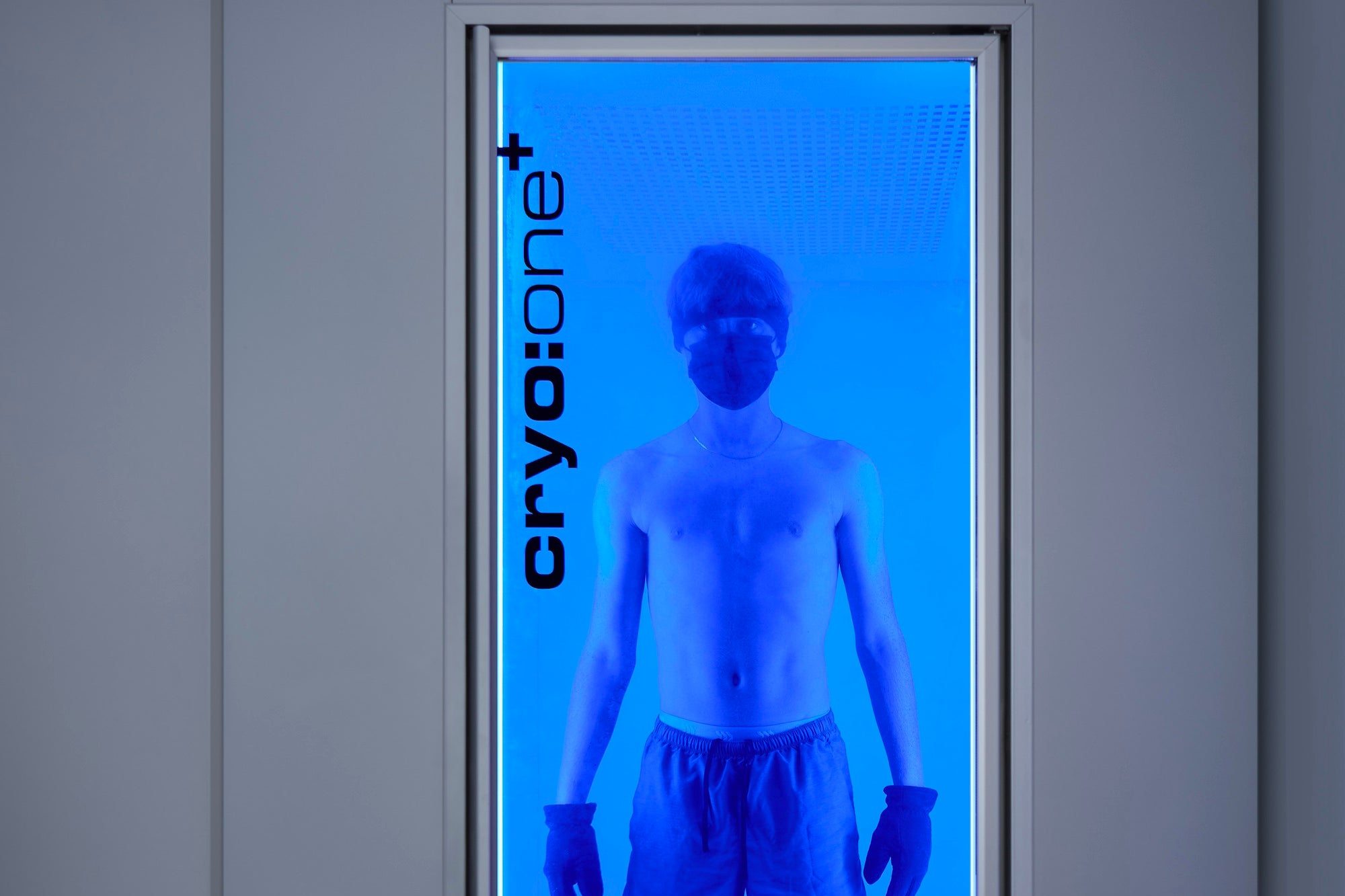 A man inside a cryo chamber, seeing through transparent door