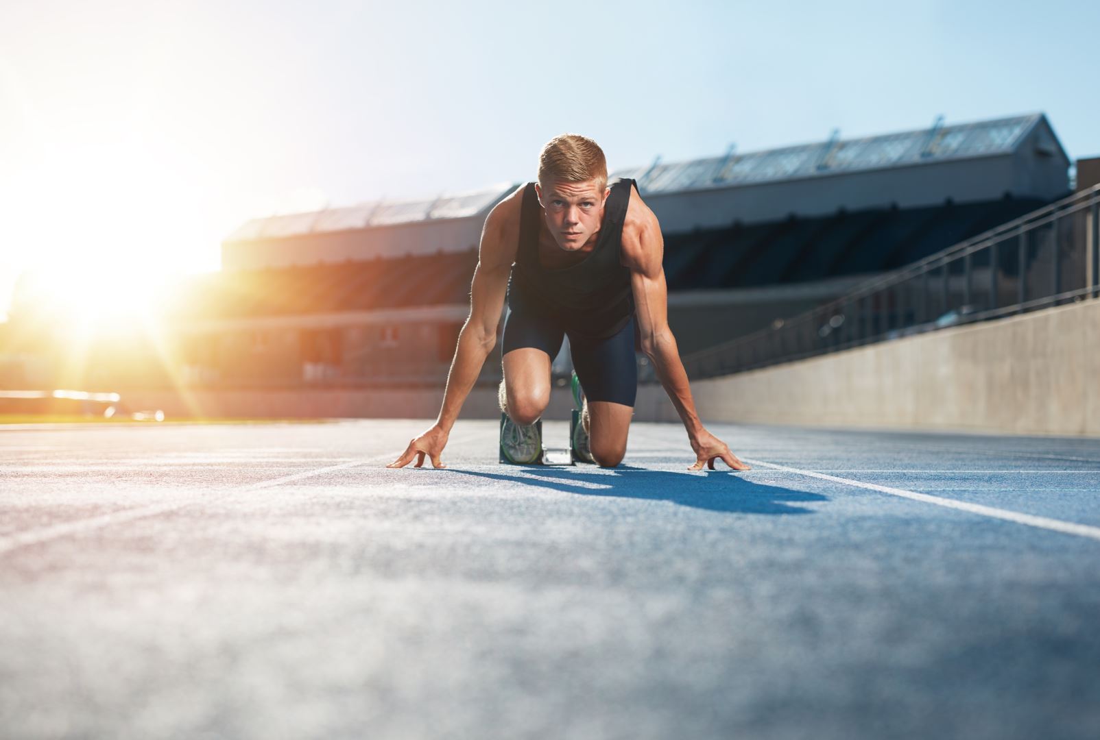 A male runner ready to sprint on a running track